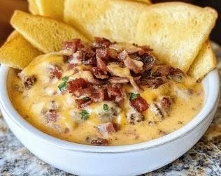 Delicious bacon cheeseburger dip served in a creamy queso style