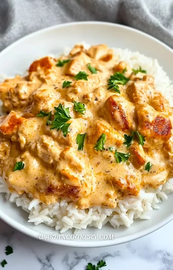 Homemade creamy smothered chicken served over fluffy rice with a rich sauce.