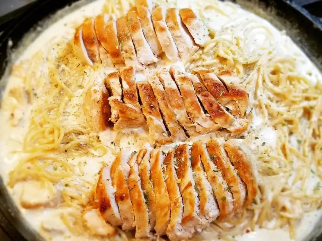 Delicious Olive Garden Chicken Alfredo served with fettuccine and Parmesan cheese