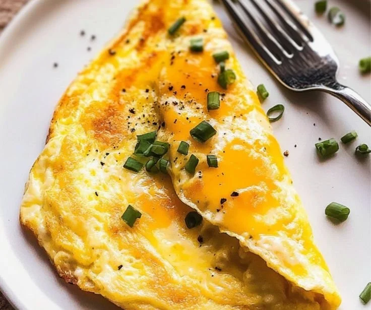 Delicious cheese omelette served on a plate with herbs