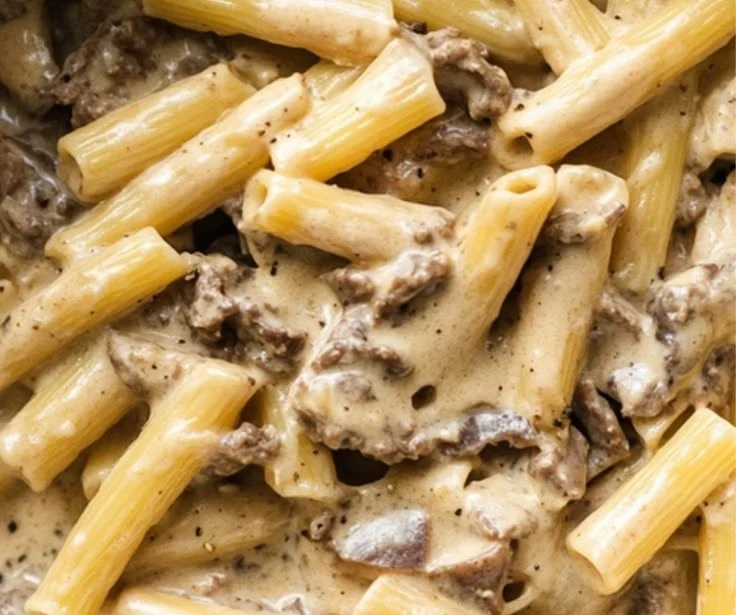 Creamy beef pasta served in a bowl with fresh herbs and cheese