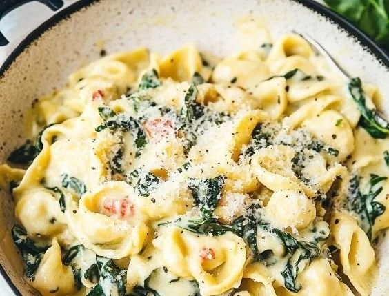 Creamy spinach tortellini dish with fresh spinach and savory sauce