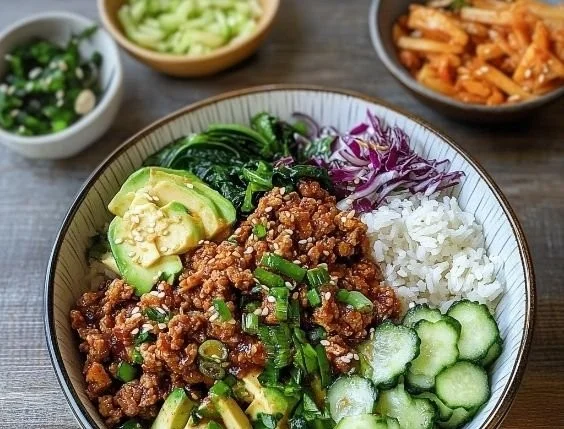 Korean rice bowl topped with ground turkey and fresh vegetables