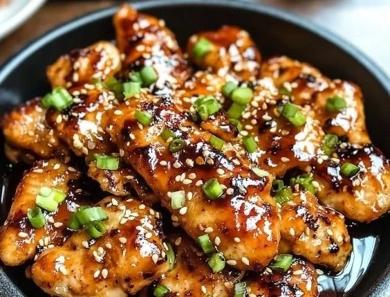 Grilled Korean-style chicken breasts garnished with sesame seeds and green onions.