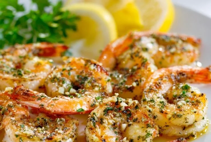 Delicious lemon garlic grilled shrimp on a plate garnished with herbs