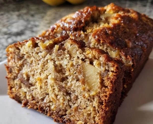 Homemade pineapple banana bread on a wooden table with slices cut