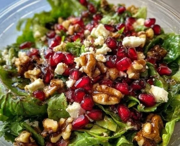 Colorful pomegranate salad recipe with fresh ingredients and garnishes.
