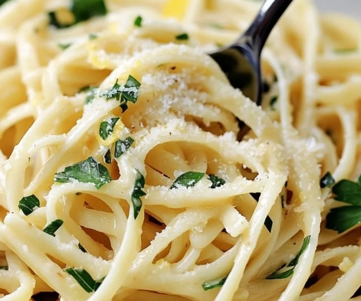 Plate of simple lemon pasta with fresh herbs and lemon zest