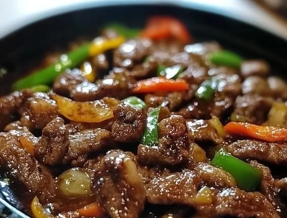 Delicious sizzled pepper steak served on a plate with colorful vegetables