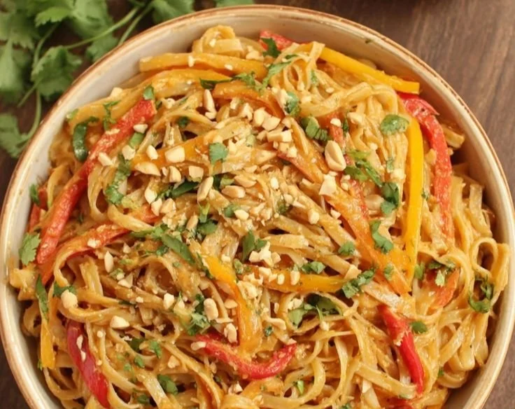 Delicious Thai Peanut Noodle Salad served in a bowl with fresh vegetables and peanuts.