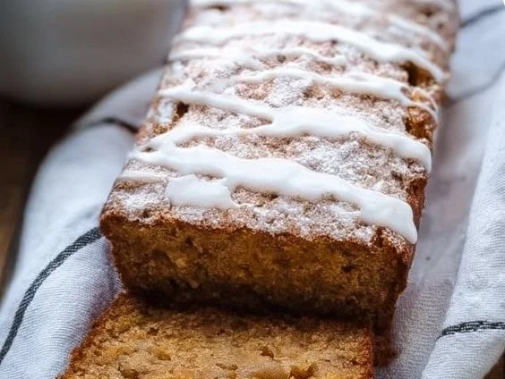 A slice of homemade Apple Cinnamon Kodiak Cakes Bread on a wooden table.