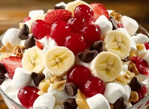 Delicious Banana Split Fluff Salad with fruits and cream topping in a bowl