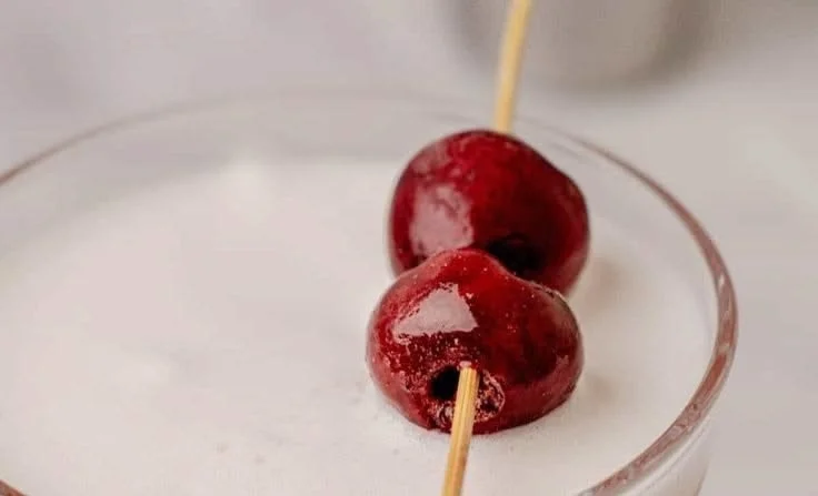 Refreshing Cherry Gin Sour cocktail served in a glass with cherries and gin