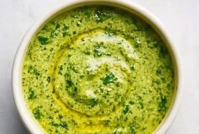 Creamy avocado cilantro lime dressing served in a bowl with fresh herbs.