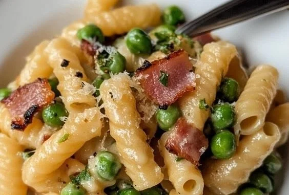 Creamy pancetta pasta with peas garnished with herbs
