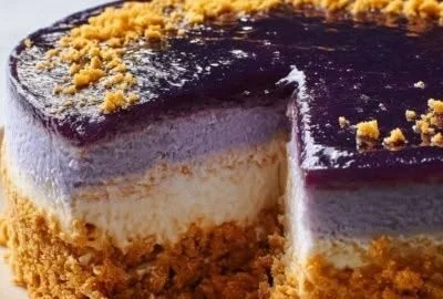 Creamy ube cheesecake topped with vibrant purple ube puree and whipped cream