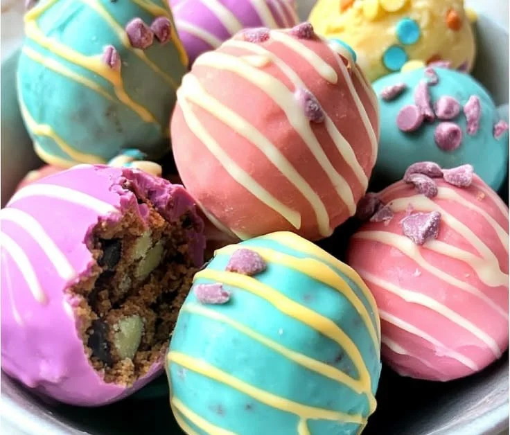 Close-up of Easter egg cookie dough truffles on a decorative plate.