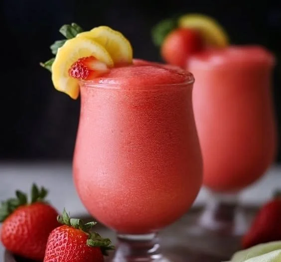 Delicious easy frozen strawberry lemonade in a glass with fresh strawberries