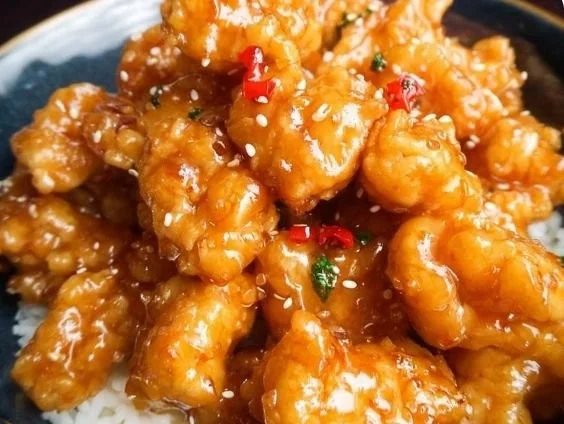 Delicious plate of homemade orange chicken with rice and vegetables