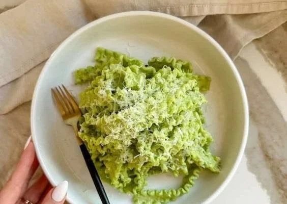 A bowl of Green Goddess Pasta Sauce with fresh herbs and vegetables.