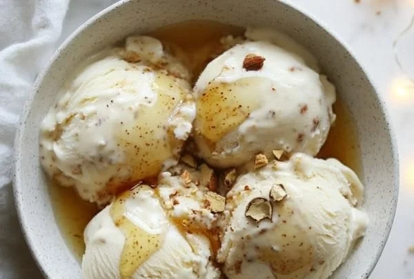 Delicious bowl of homemade Honey Nutmeg Ice Cream topped with nuts and spices