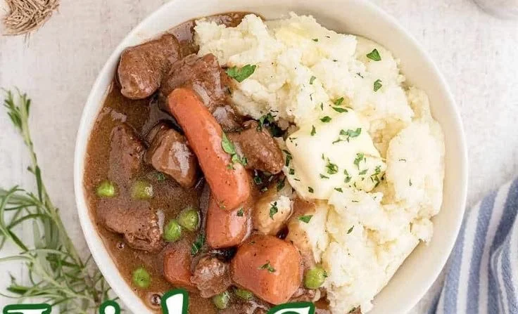 Bowl of Irish stew served with creamy mashed potatoes on a rustic table
