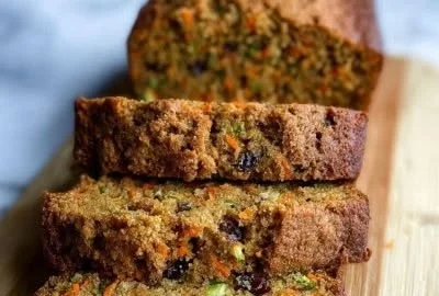 Delicious spiced zucchini carrot bread slice on a wooden cutting board