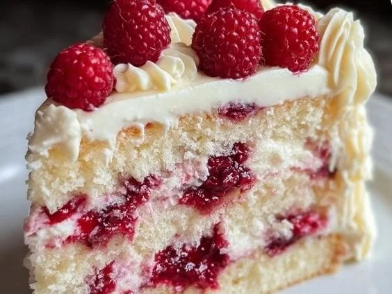 Delicious slice of White Chocolate Raspberry Cake with fresh raspberries