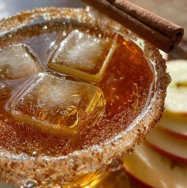 Apple-flavored cider martini served in a chilled glass with an apple slice garnish.