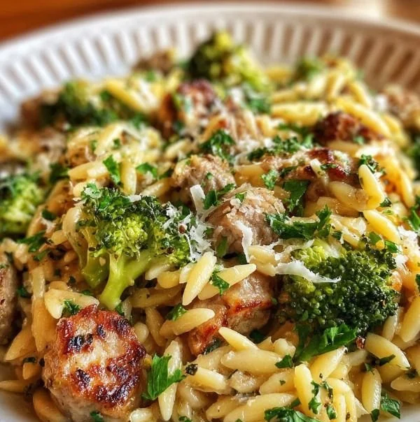 Plate of chicken sausage with broccoli and orzo in a bowl