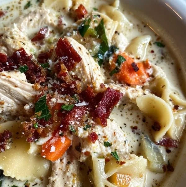 Creamy Chicken Parmesan Pasta Soup in a bowl with ingredients on the side.