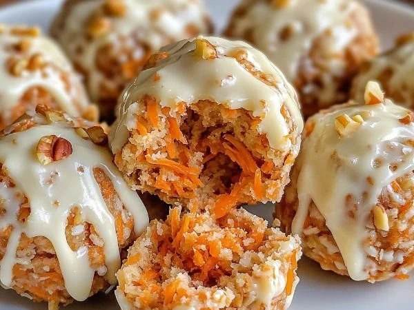 No-bake carrot cake bites served on a plate with frosting and walnuts