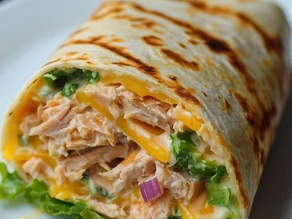 Delicious tuna melt wrap filled with cheese and fresh vegetables